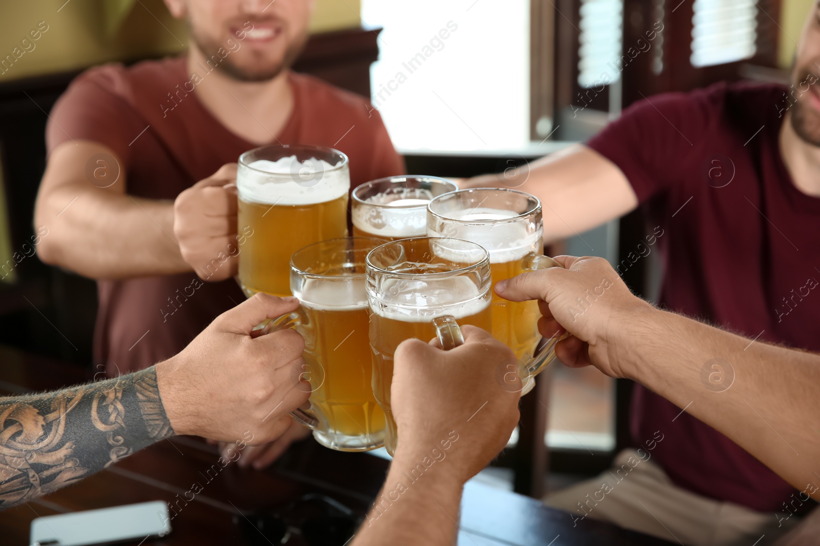 Photo of Friends clinking glasses with beer in pub