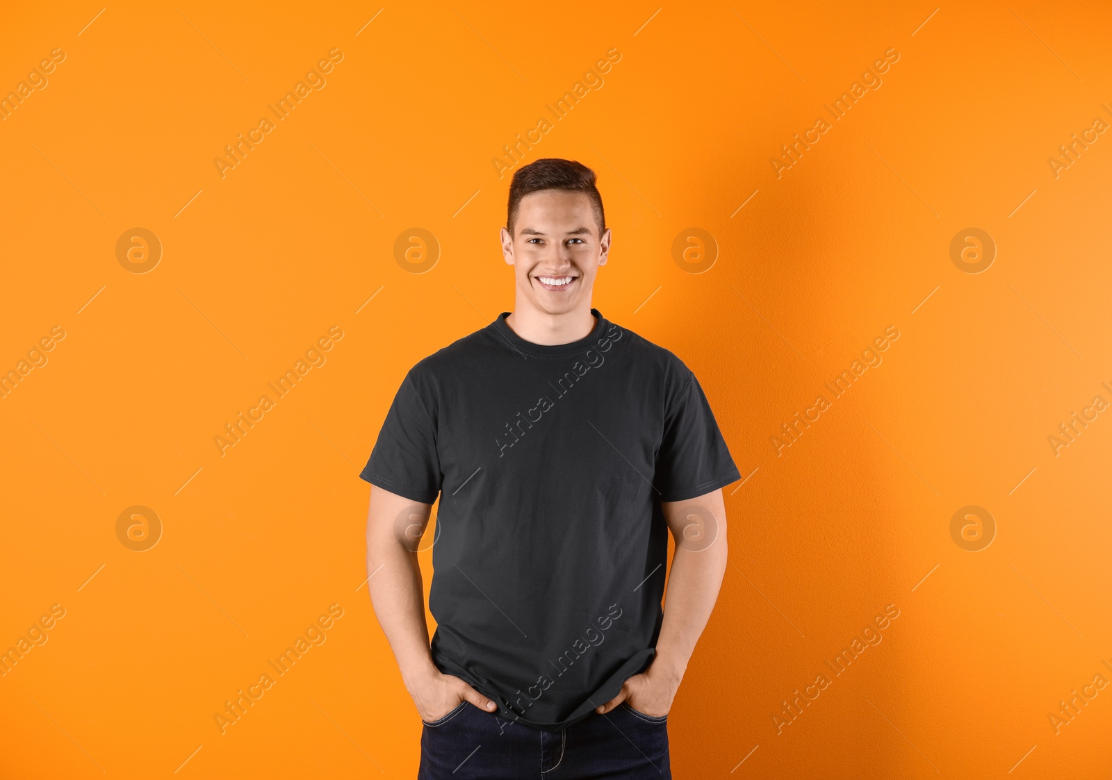 Photo of Young man in black t-shirt on color background. Mockup for design