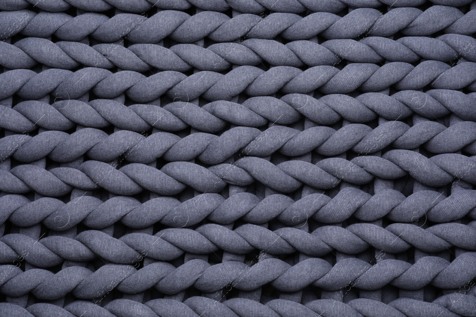 Photo of Top view of grey chunky knit blanket as background