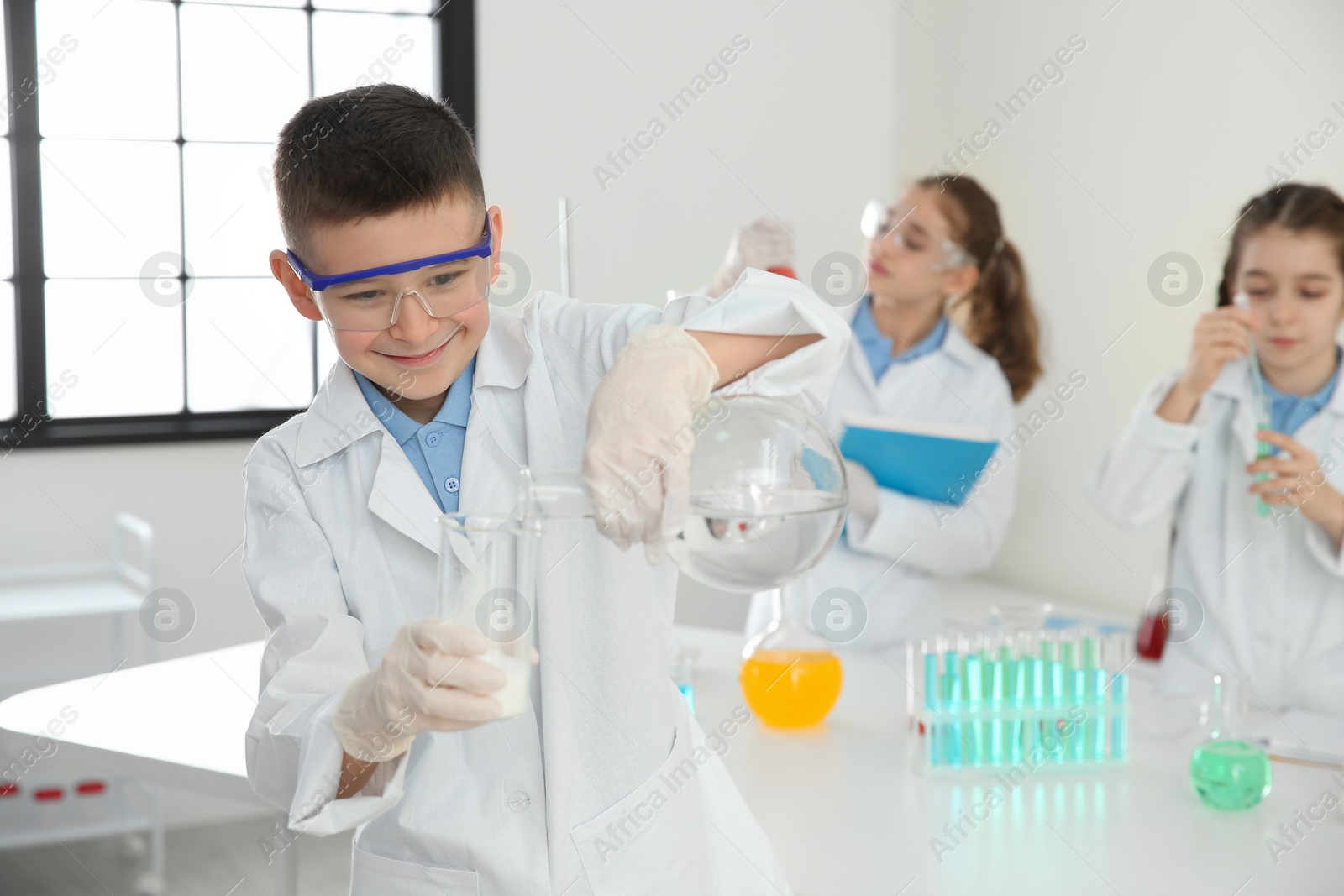 Photo of Smart schoolboy making experiment in chemistry class