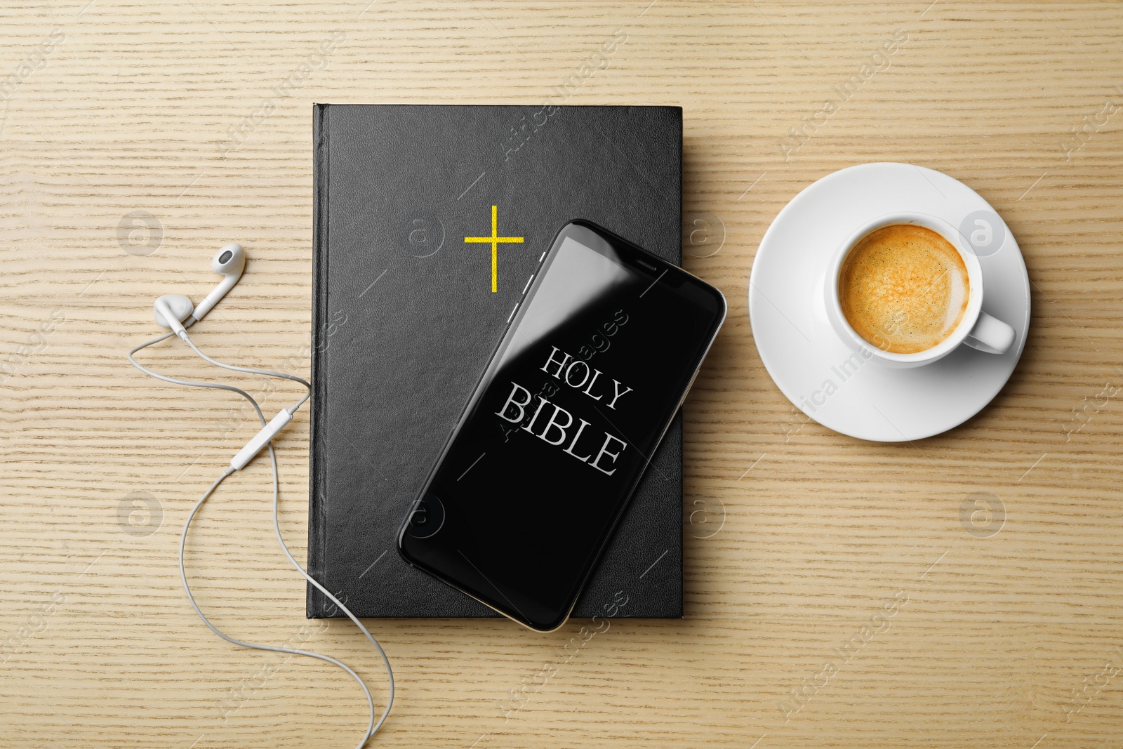 Photo of Bible, phone, cup of coffee and earphones on wooden background, flat lay. Religious audiobook