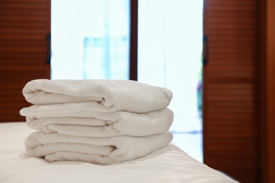 Photo of Stacked towels on bed in hotel room, space for text