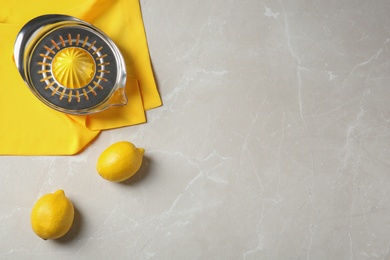 Photo of Flat lay composition with ripe lemons and juicer on gray table