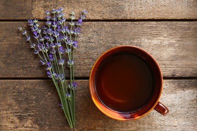 Tasty herbal tea and fresh lavender flowers on wooden table, flat lay