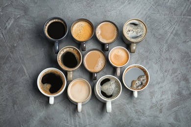 Photo of Many cups with tasty aromatic coffee on grey table, flat lay