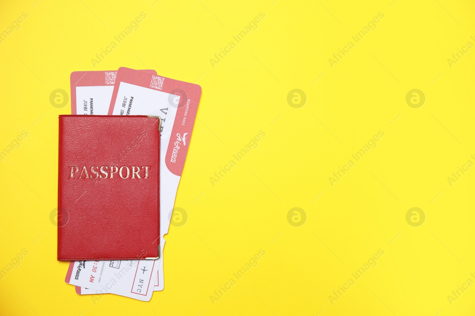 Photo of Passport with tickets on yellow background, top view. Space for text