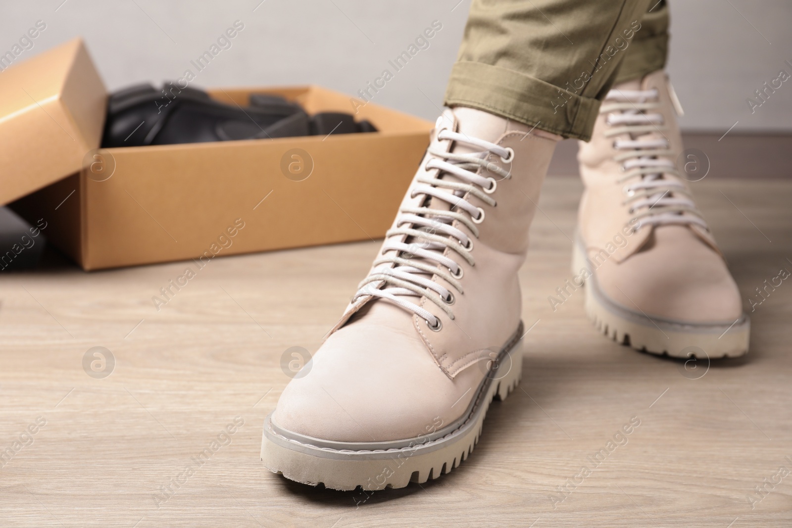 Photo of Woman wearing stylish leather boots indoors, closeup. Space for text