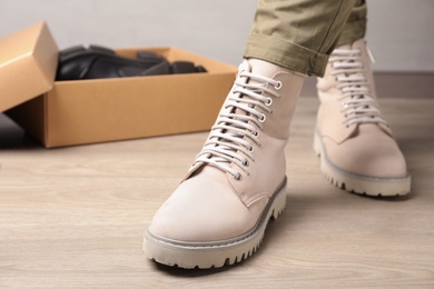 Woman wearing stylish leather boots indoors, closeup. Space for text