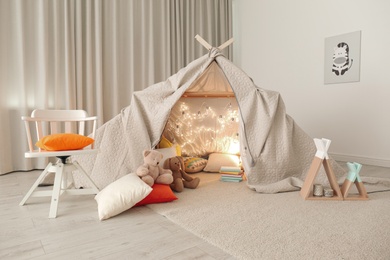 Play tent decorated with festive lights in modern child's room