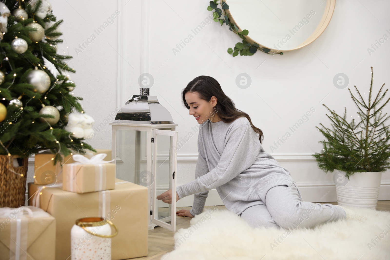 Photo of Woman lighting up candles on floor at home