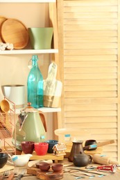 Many different cooking utensils in room. Garage sale