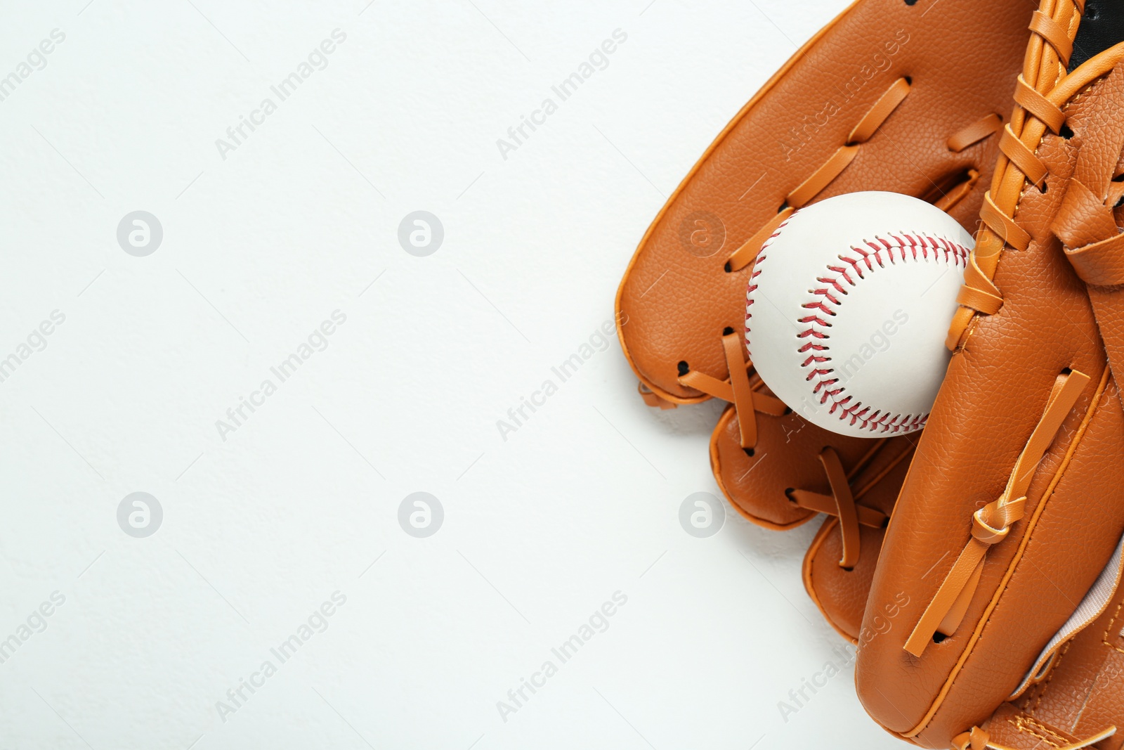 Photo of Catcher's mitt and baseball ball on white background, top view with space for text. Sports game