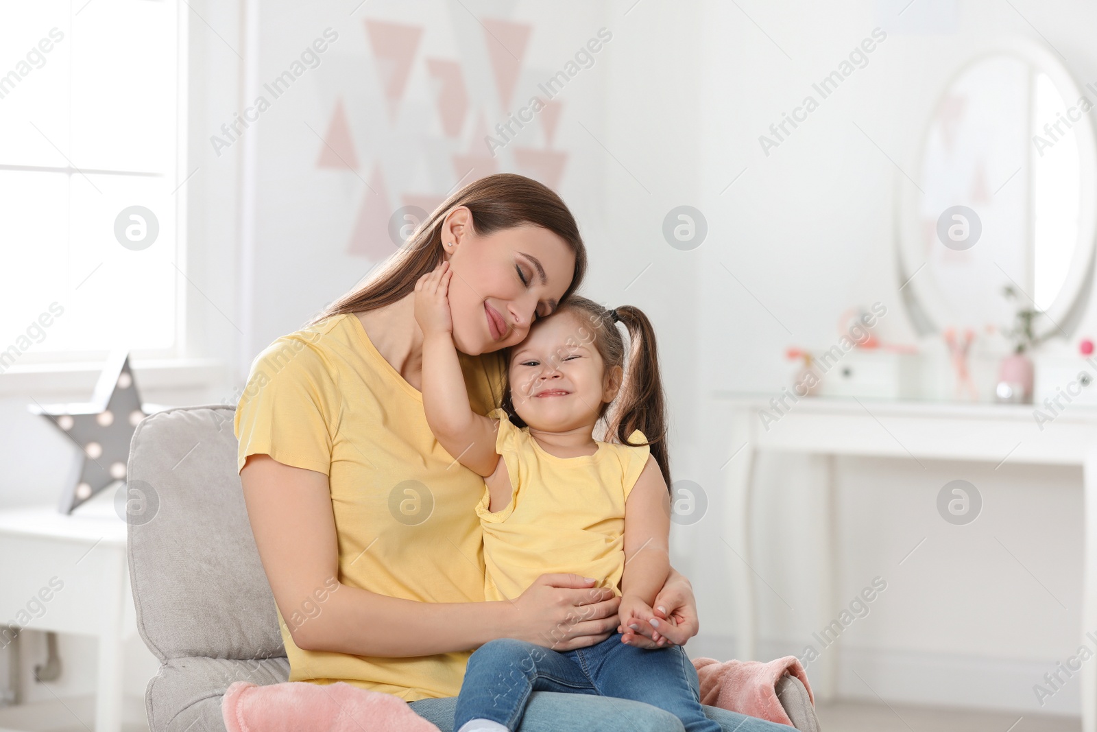 Photo of Young mother with little daughter at home