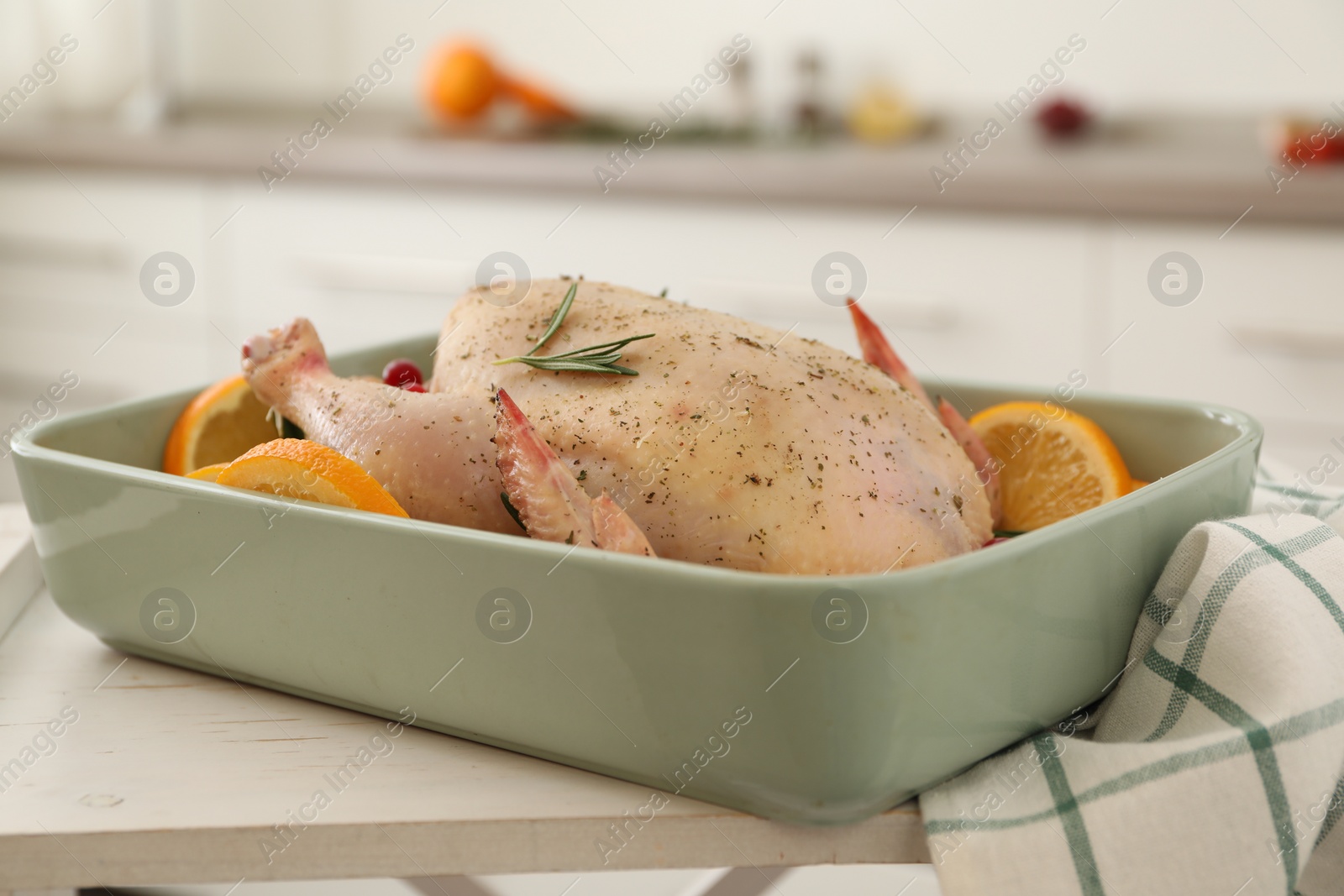 Photo of Chicken with orange slices in baking pan on wooden table