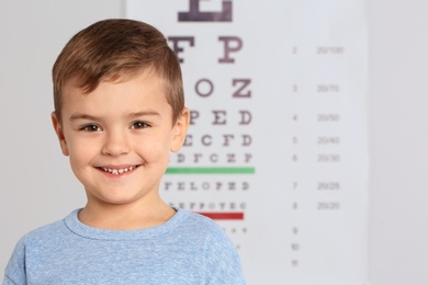Photo of Portrait of cute little boy visiting children's doctor, space for text. Eye examination