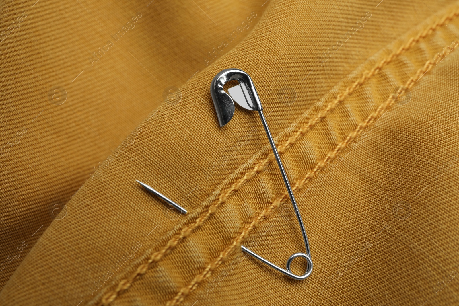 Photo of Closeup view of metal safety pin on clothing