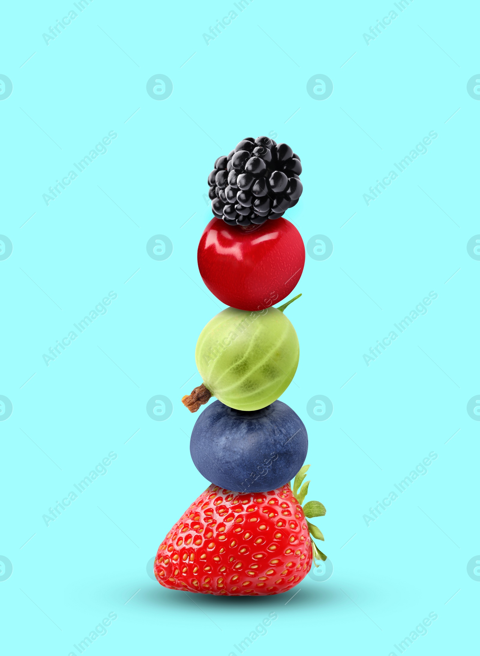 Image of Stack of different fresh tasty berries and cherry on cyan background