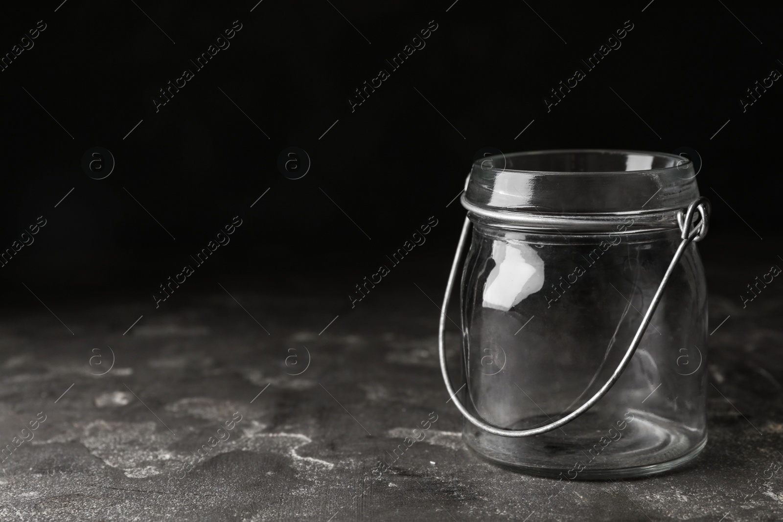 Photo of Empty glass jar on grey stone table, space for text