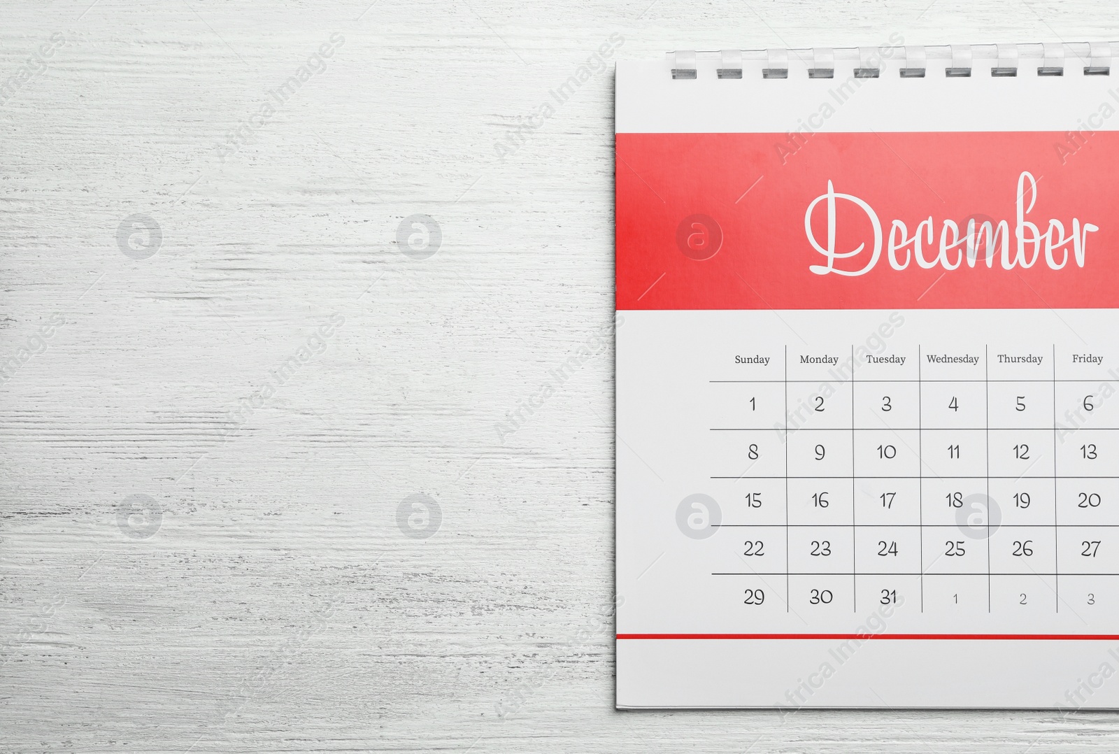 Photo of December calendar on white wooden background, top view. Space for text
