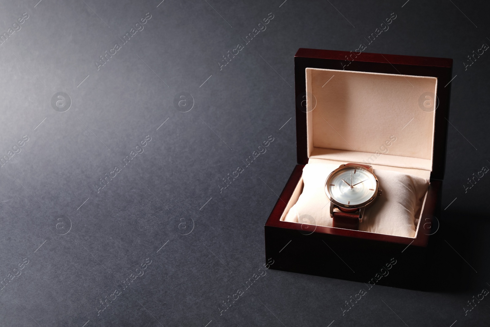 Photo of Luxury wrist watch in box on black background, space for text