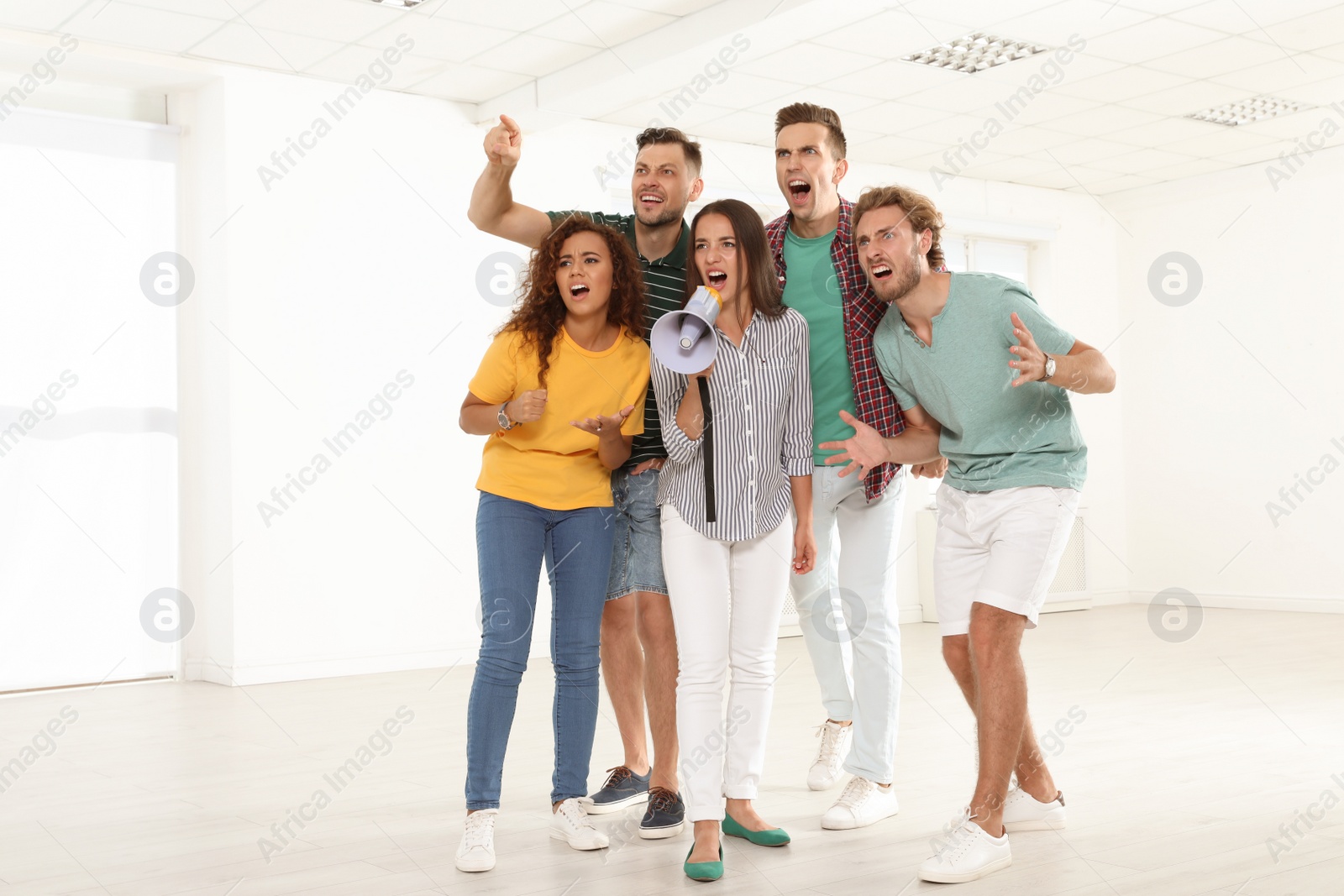 Photo of Group of protesting young people with megaphone indoors