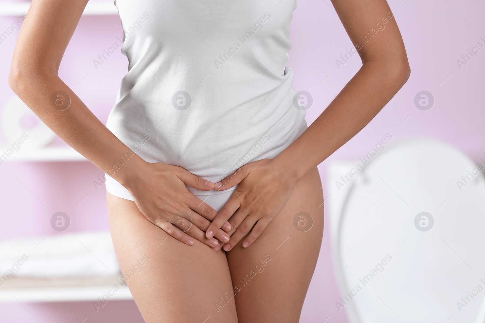 Photo of Young woman holding hands on belly at home. Gynecology