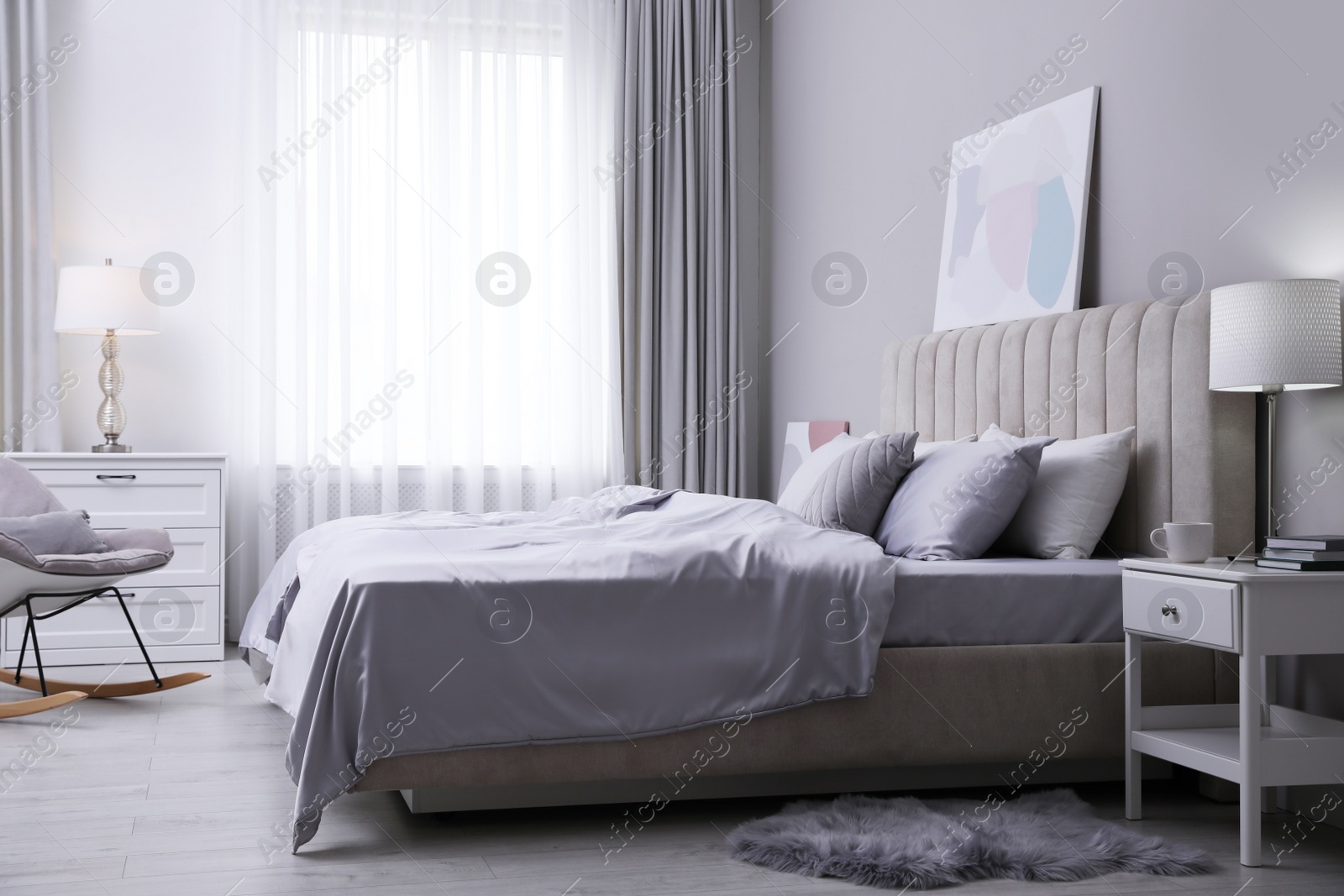 Photo of Cozy bed with soft silky bedclothes in light room