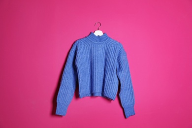 Photo of Hanger with stylish sweater on color background