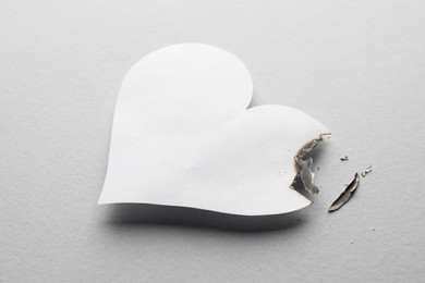 Burned paper heart on white background. Broken heart