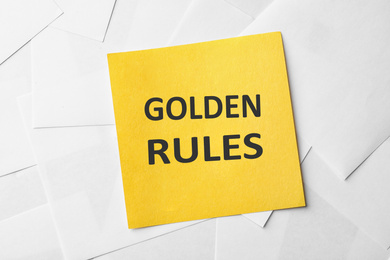 Note with words GOLDEN RULES on paper sheets, top view