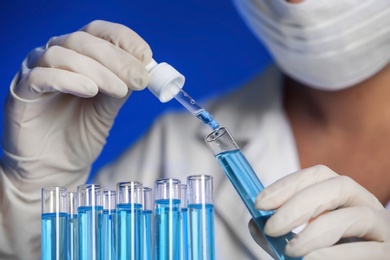 Scientist dripping reagent into test tube with sample, closeup. Laboratory analysis