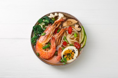 Photo of Delicious ramen with shrimps and egg on white wooden table, top view. Noodle soup
