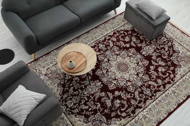 Cozy room interior with stylish furniture and soft carpet with beautiful pattern, view from above