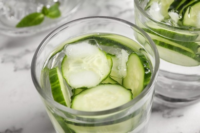 Photo of Glass with fresh cucumber water on table, closeup