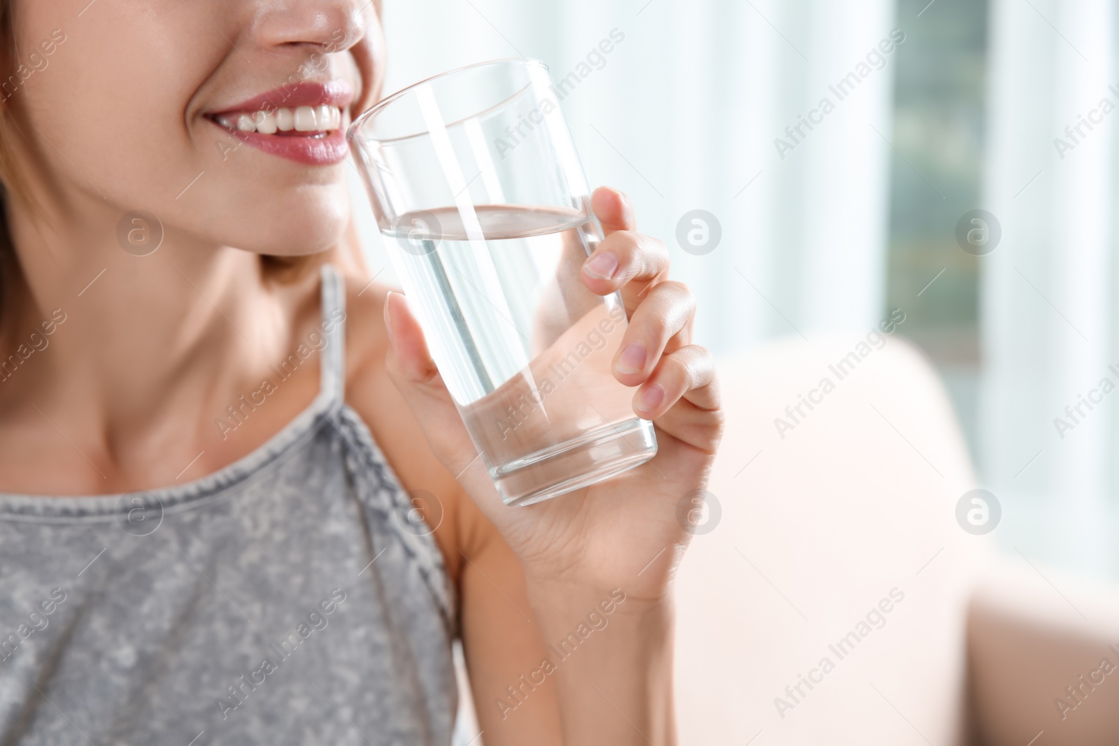 Photo of Woman drinking clean water from glass at home, closeup