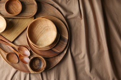 Set of wooden dishware and utensils on table, flat lay. Space for text