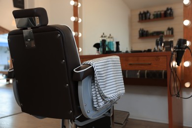 Photo of Stylish hairdresser's workplace with professional armchair in barbershop