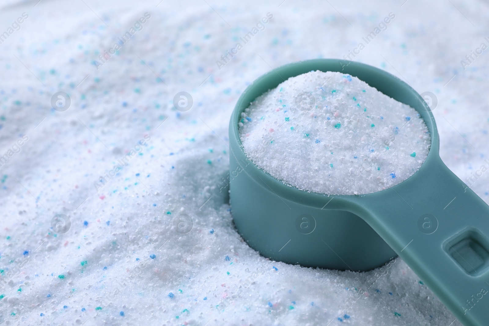 Photo of Measuring spoon with laundry powder, closeup view. Space for text