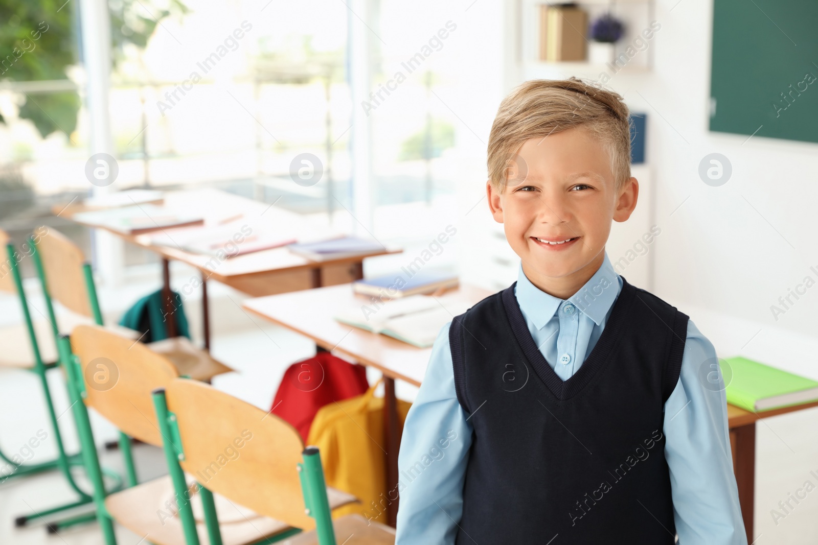 Photo of Little boy in classroom. Stylish school uniform