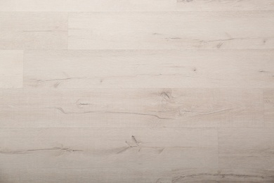 Photo of Light wooden laminate as background, top view. Floor covering