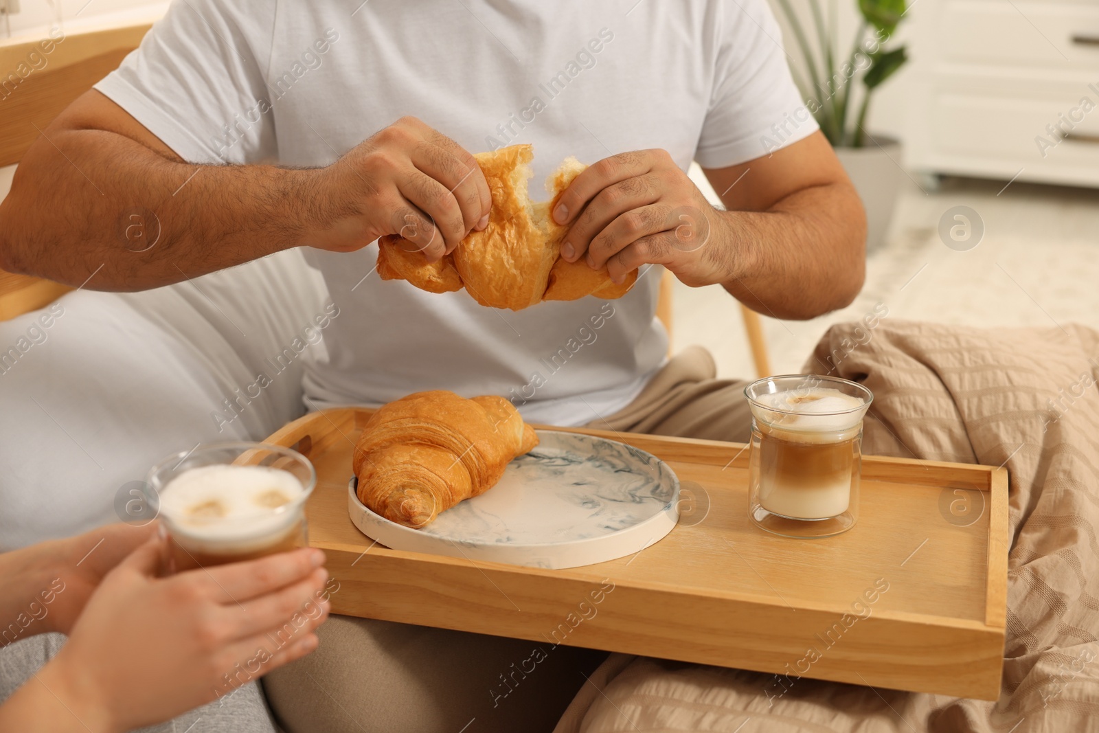Photo of Couple having breakfast together on bed at home, closeup