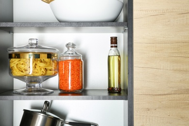 Photo of Products and kitchen utensils on modern shelving unit