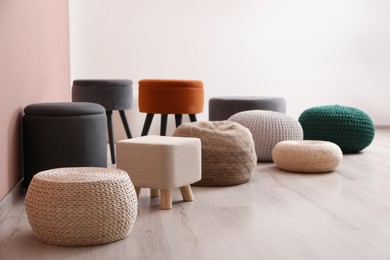 Photo of Different stylish poufs and ottomans in room