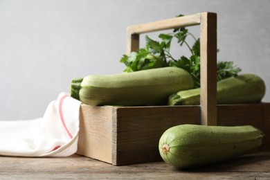Photo of Crate with ripe zucchinis on wooden table