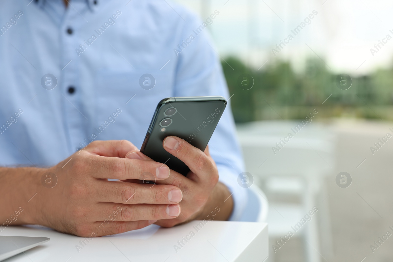 Photo of Man using smartphone in outdoor cafe, closeup. Space for text