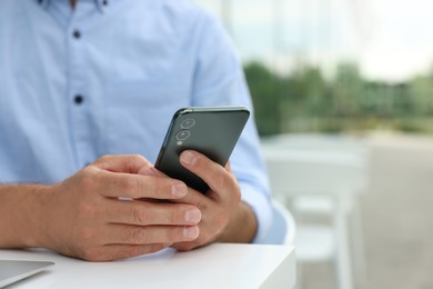 Photo of Man using smartphone in outdoor cafe, closeup. Space for text