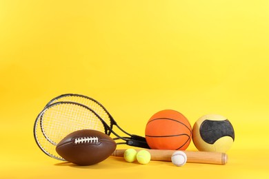 Photo of Setdifferent sports equipment on yellow background