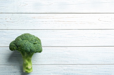 Photo of Fresh green broccoli on white wooden table, top view. Space for text