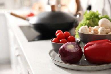 Different vegetables on countertop in kitchen, space for text