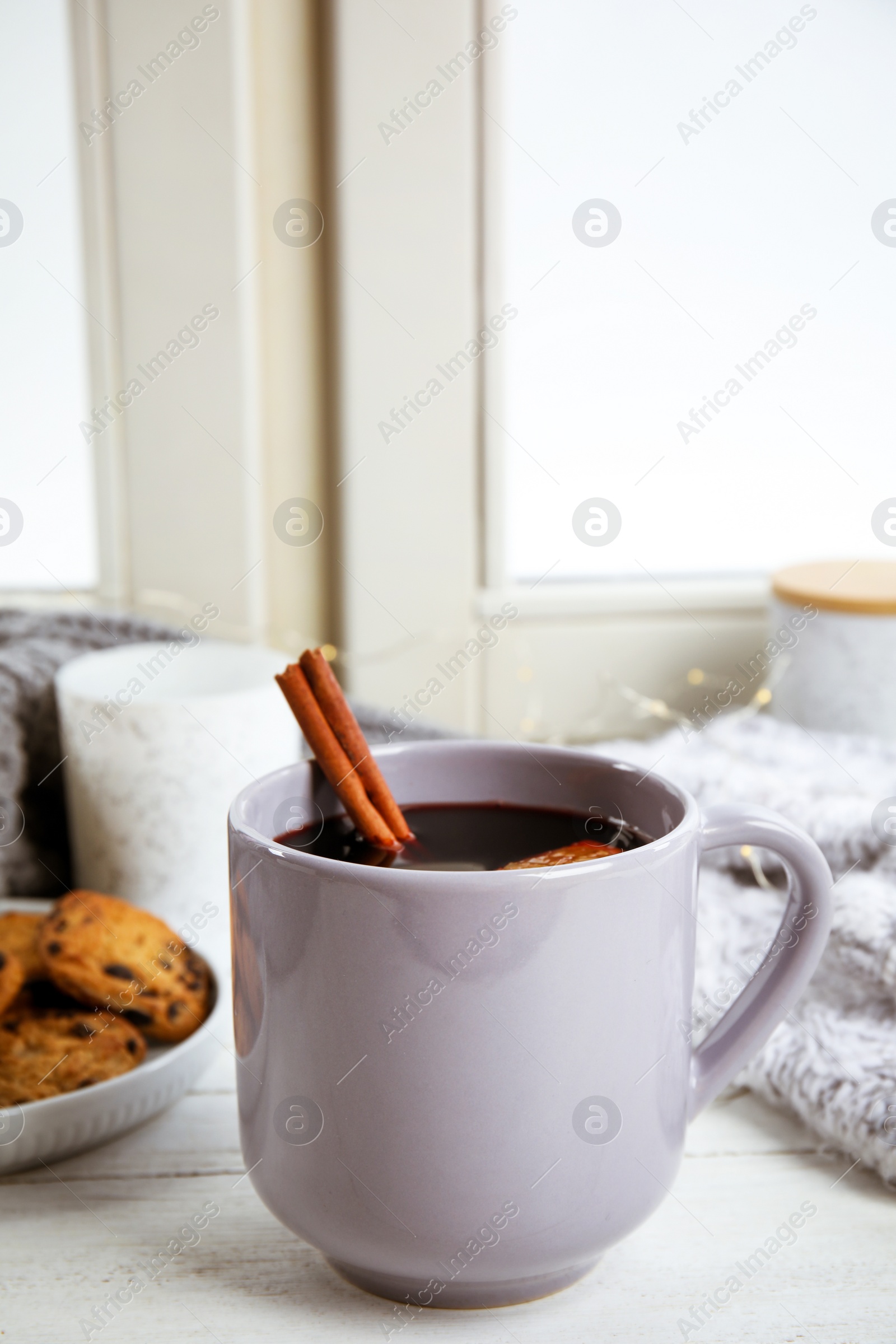 Photo of Cup of hot mulled wine on window sill. Winter drink